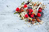 Tasty colorful ingredients for cooking breakfast or smoothie (fresh berries, nuts, oat flakes, dried fruits, chia seeds and honey) over concrete textured background