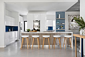 Barstools at island counter in modern kitchen with white cabinets