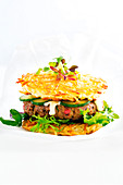 Ramen-Burger mit Gurke und Salat vor weißem Hintergrund