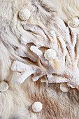 An arrangement of of white shades made from animal fur, corral and truffle pralines (full frame)
