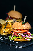 Burgers and potato chips on a black background