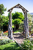 Gartenbogen aus Holz über dem Weg im exotischen Garten