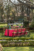 Table set for garden party below lanterns hung from frame