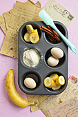 Ingredients for cinnamon and banana muffins in a muffin tin