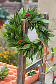Wreath Of Laurel And Hot Peppers Hung On Chair Back
