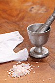 Coarse salt on a table with a mortar
