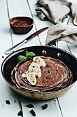 Chocolate pancakes with banana and chocolate icing