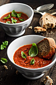 Roasted tomatoes cream soup with basil and slice of bread