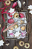 A carton with vintage glass pinecones, branches, cinnamon stars and jam cookies