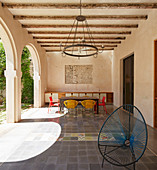 Colourful chairs around table in loggia with tiled floor