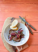 Beef steaks with balsamic onions and baguette slices