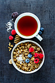 Granola muesli with berries and a cup of tea (top view)