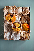 White eggs and yellow paper rosettes in box