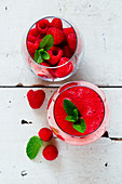 Top view of freshly made raspberry smoothie with fresh berries over white rustic background