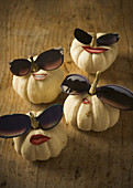 Pumpkins decorated with stick-on mouths and sunglasses