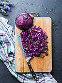Cutting purple cabbage on wooden board
