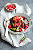 Oven-baked beetroot with radishes, feta cheese and walnuts