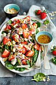 Spinach salad with strawberries, green asparagus, feta cheese and almonds