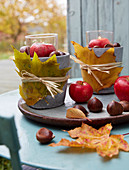 DIY-Windlichter mit Herbstlaub, Kastanien und Apfel
