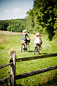 Zwei junge Frauen fahren mit Fahrrädern zum Picknick