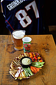 Vegetables with dip and beer, NFL shirt in a background (USA)
