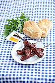 Grilled pork skewers with crusty rolls