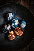 Easter eggs dyed with natural colours and decorated with flowers in a bowl