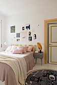 Collage of pictures above bed in feminine bedroom