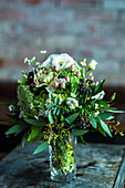 Festive posy of roses, berries, eucalyptus and daisies