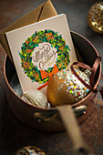 Christmas card and Christmas bauble in saucepan