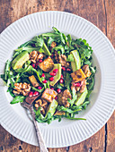 Arugula salad with organic sweet potatoes, avocado, grilled nuts and pomegranate