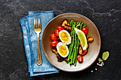 A healthy vegetarian breakfast with eggs, asparagus, mushrooms and tomatoes