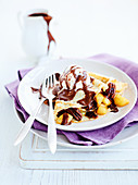 Crepes with pears, pecan nuts, chocolate sauce and ice cream