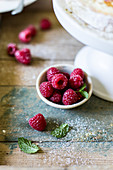 Raspberries on rustic wooden surface with mint