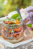 Layered salad with qunioa and vegetables in a jar for a summer picnic
