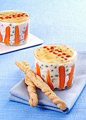 Russian salad served in a glass with bread sticks