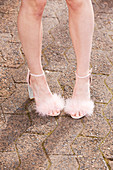 Frau trägt Sandalen mit Kunstpelz-Besatz