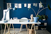 Weiße Tischplatte auf Holzböcken im Arbeitszimmer mit blauer Wand