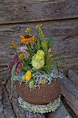 Herbstliches Blumengesteck in der Schale der Sapucaia-Nuss