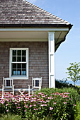 Flowering Echinaceas outside house with wooden shingled roof