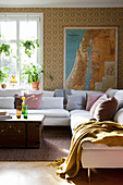 Sunlight falling into vintage-style living room with map on wall