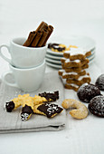 Various Christmas biscuits and espresso cups with cinnamon sticks
