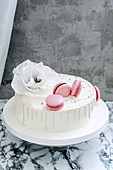 A white wedding cake with pink macaroons
