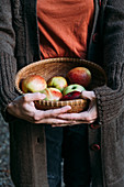 Apples in a basket with hands