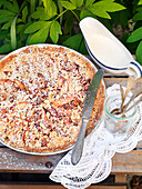 Apple pie with almonds, powdered sugar and cream