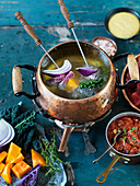 Fondue with beef, pumpkin, kale, red onions and salsa