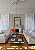 Two sofas facing one another either side of three coffee tables in living room