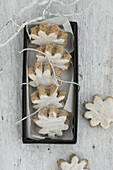 Iced flower-shaped cinnamon biscuits in a box