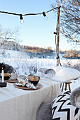 Gedeckter Tisch mit Weihnachtsdekoration im Garten