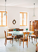 Moderne Esstisch mit Glasplatte und Biedermeier-Möbel in hellem Esszimmer